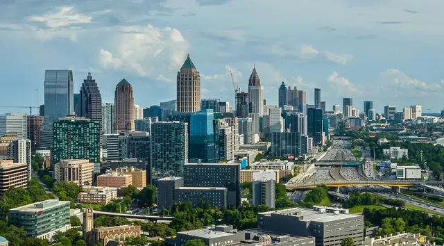 Midtown and Downtown Atlanta skyline beneath a blue sky