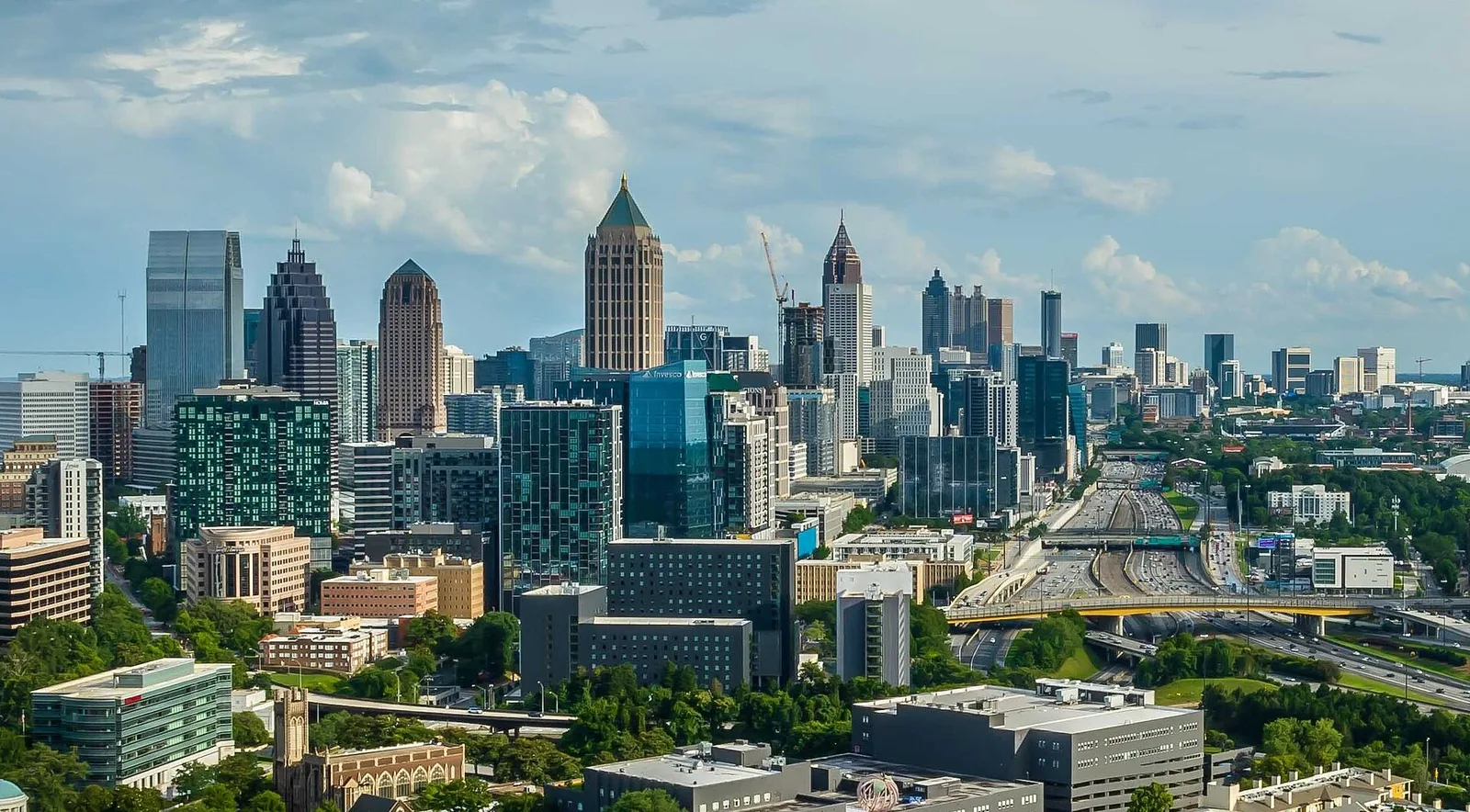 Midtown and Downtown Atlanta skyline beneath a blue sky