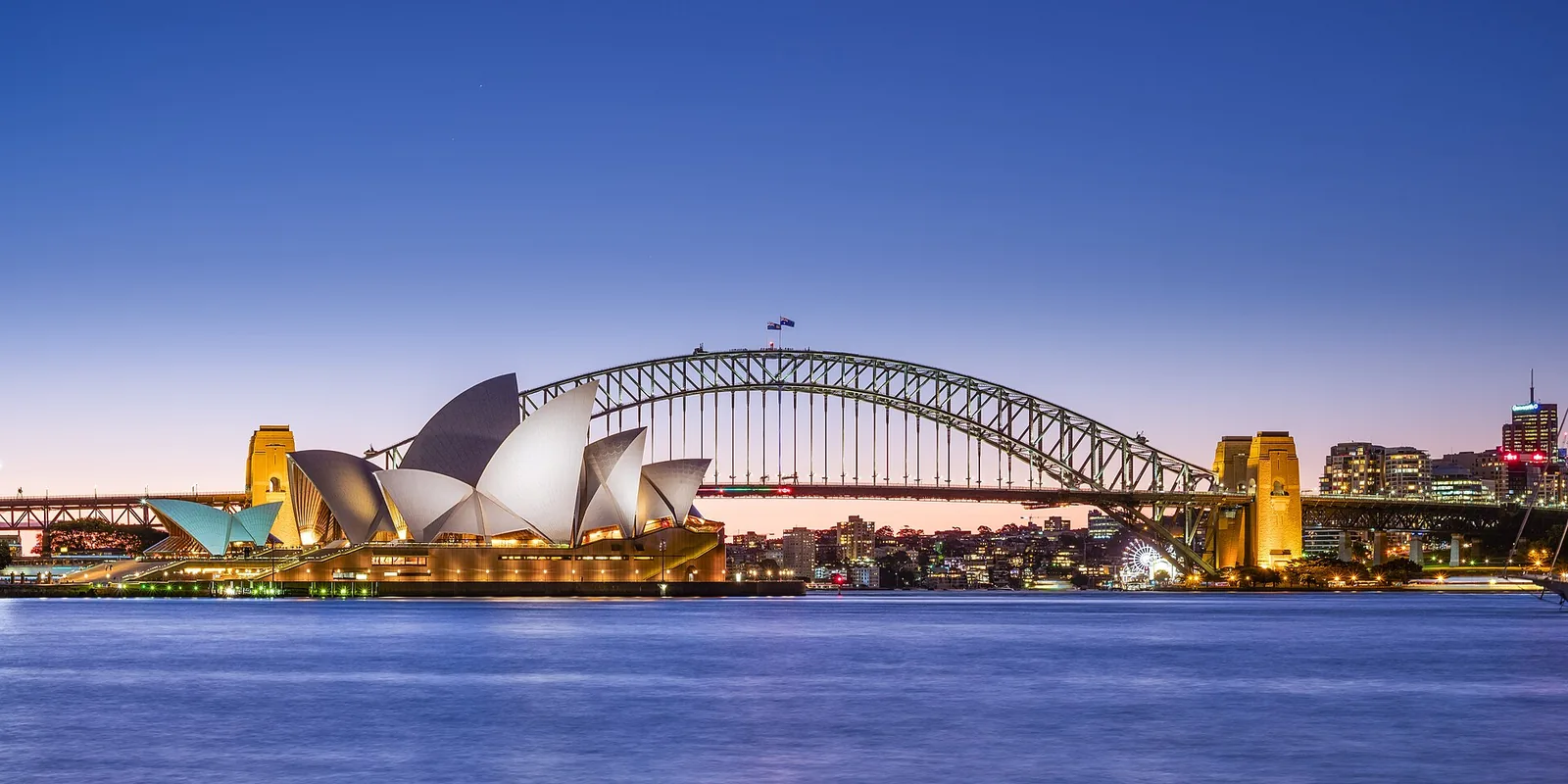 Sydney Opera House and Harbour Bridge illuminated at dusk